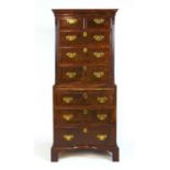 An early 20th century,18th century style walnut chest on chest, the cavetto cornice over two short