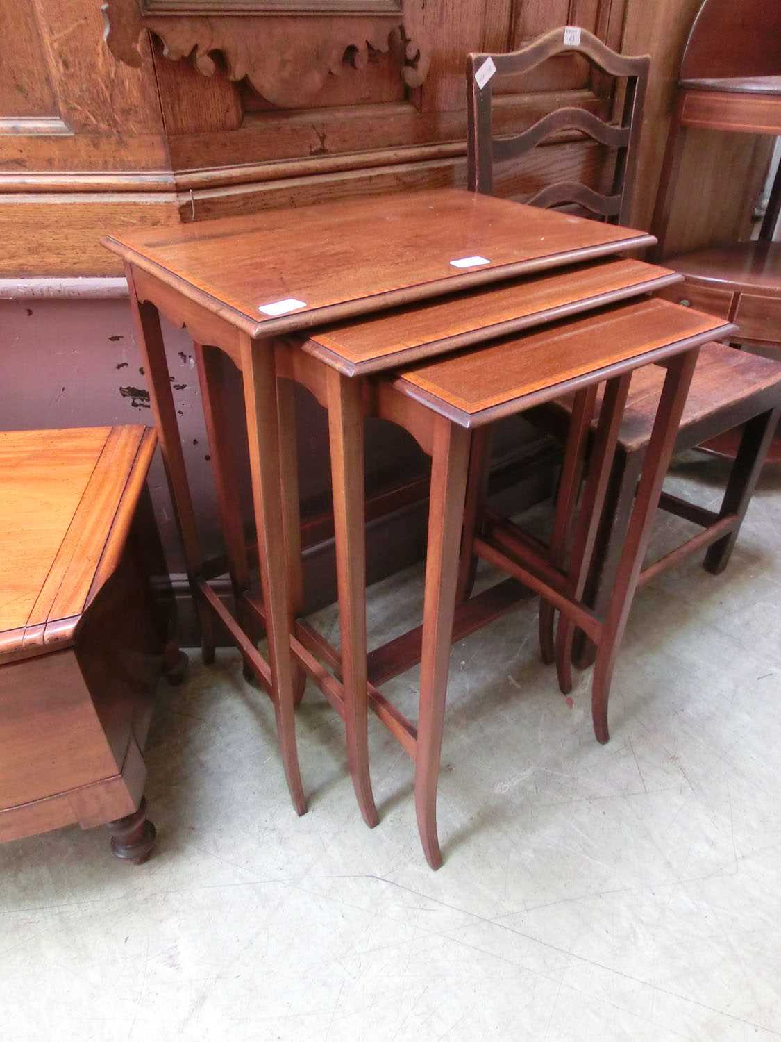 A nest of three Edwardian mahogany satinwood banded tables