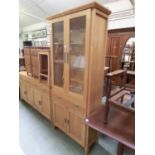 A modern pine display cabinet with two glazed doors over single drawer and two cupboard doors