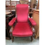 A Victorian walnut framed nursing chair upholstered in a red draylon fabric