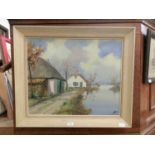 A framed oil on canvas of cottages by river scene signed bottom right