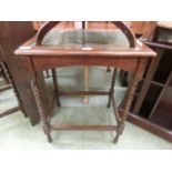 A mid-20th century oak occasional table with bobbin supports and a tooled leather inset to top