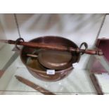 A large twin handled copper bowl together with a copper bed warming pan