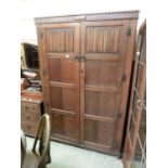 An early 20th century oak linen fold design two door wardrobe