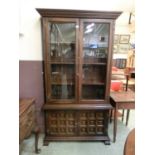 A reproduction Mexican style cabinet having a pair of glazed doors to top with panel doors below