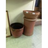 Two terracotta plant pots along with a red glazed plant pot