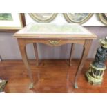 A reproduction walnut occasional table having a tapestry under glass to top