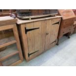 An early 20th century pine two door cupboard