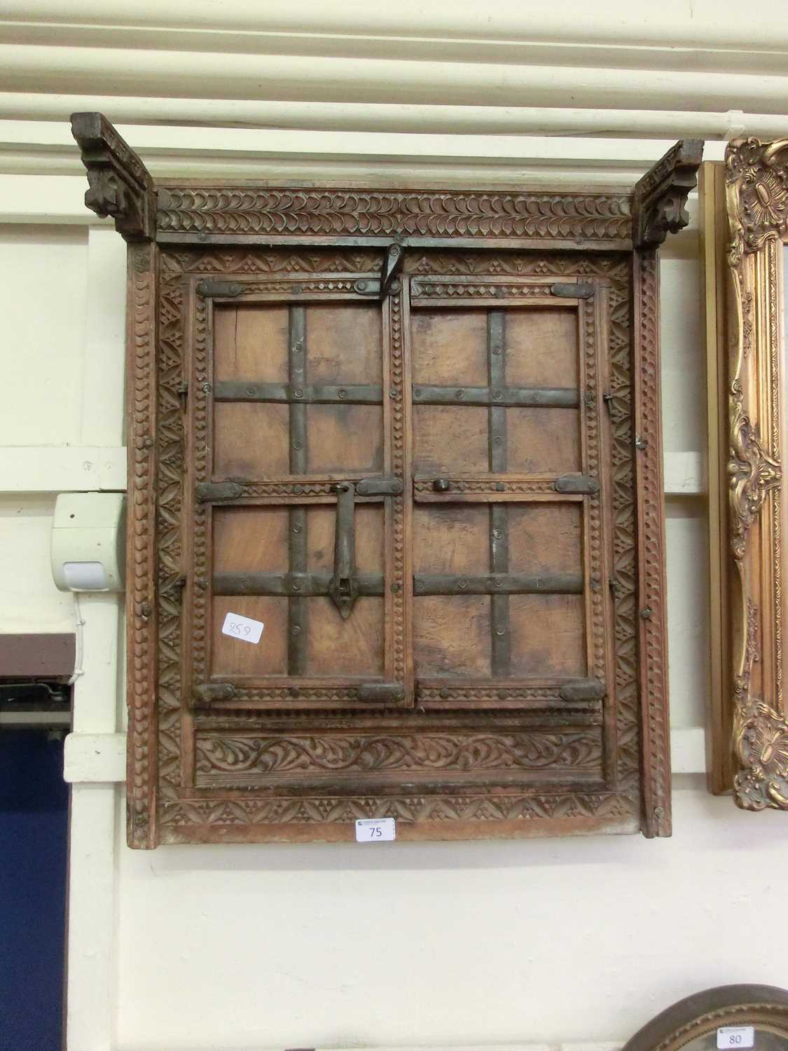 An Indian carved window with panelled doors