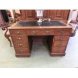 An early 20th century oak twin pedestal desk with tooled black leather insert to top