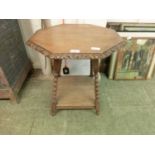 An early 20th century oak octagonal occasional table on bobbin legs and under tier