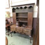 An early 20th century oak dresser having a plate rack to top