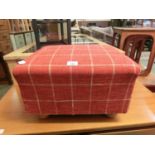 A modern red checked upholstered footstool