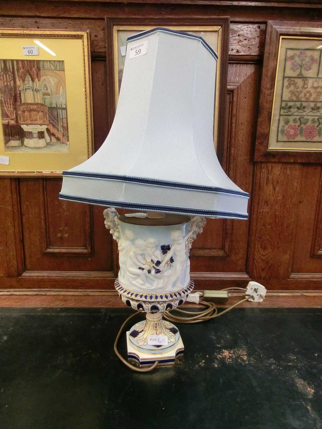 A ceramic columned table lamp with putto design