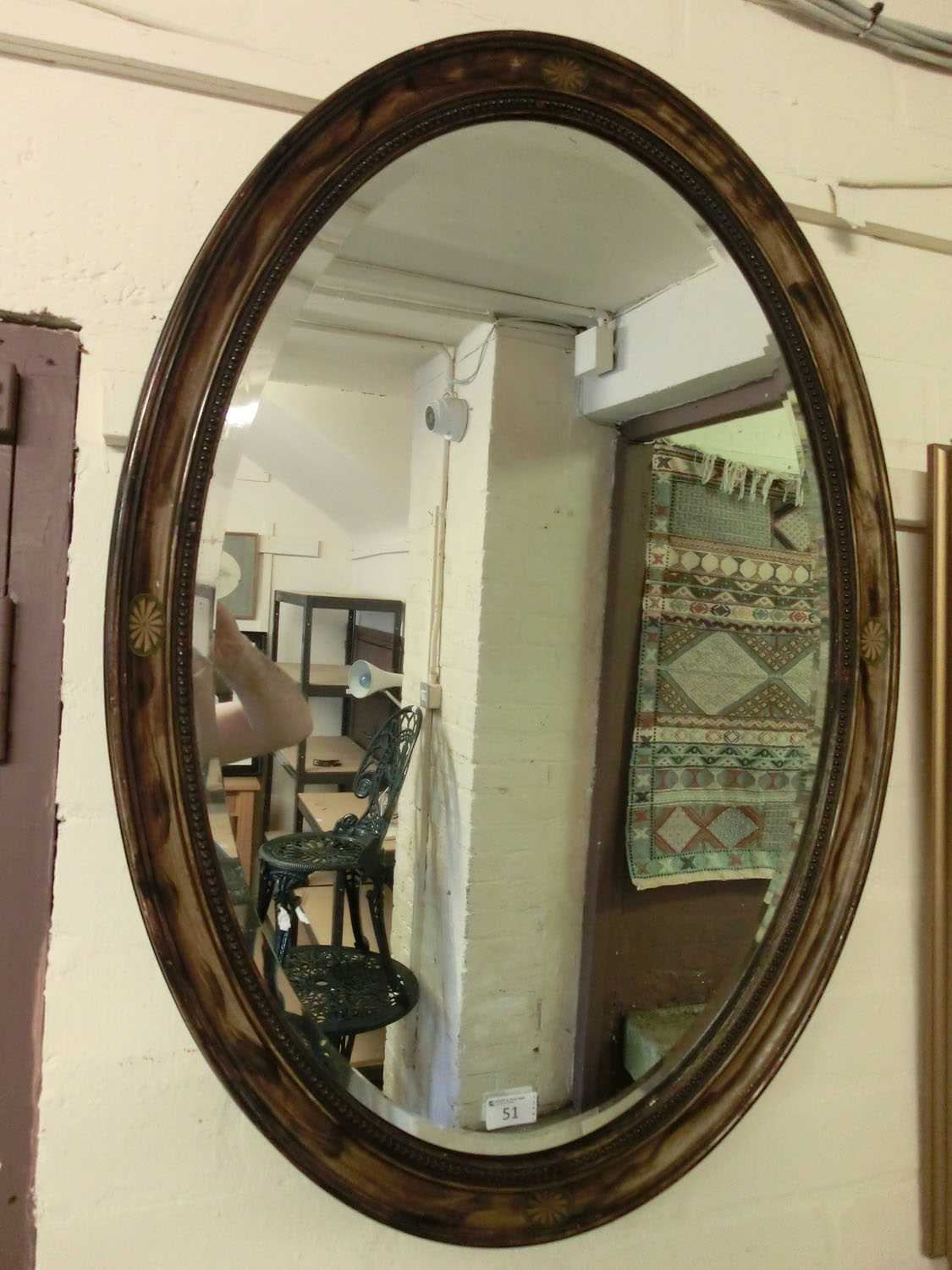 A simulated wooden oval bevel glass wall mirror