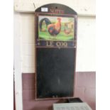 A reproduction black board with a print of cockerel and hen