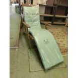 A teak reclining garden chair with green seat cover