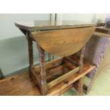 A mid-20th century oak swivel top drop leaf occasional table