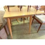 A mid-20th century laminated dining table with one drop leaf