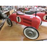 A reproduction red tin plate racing car
