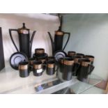 A Portmeirion pottery black coffee set with a gilt decoration