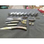 A quantity of metalwork plate setting stands, pen knives, studs, etc