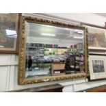 An ornate gilt framed bevel glass wall mirror