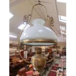 A brass and white glass ceiling hanging oil lamp