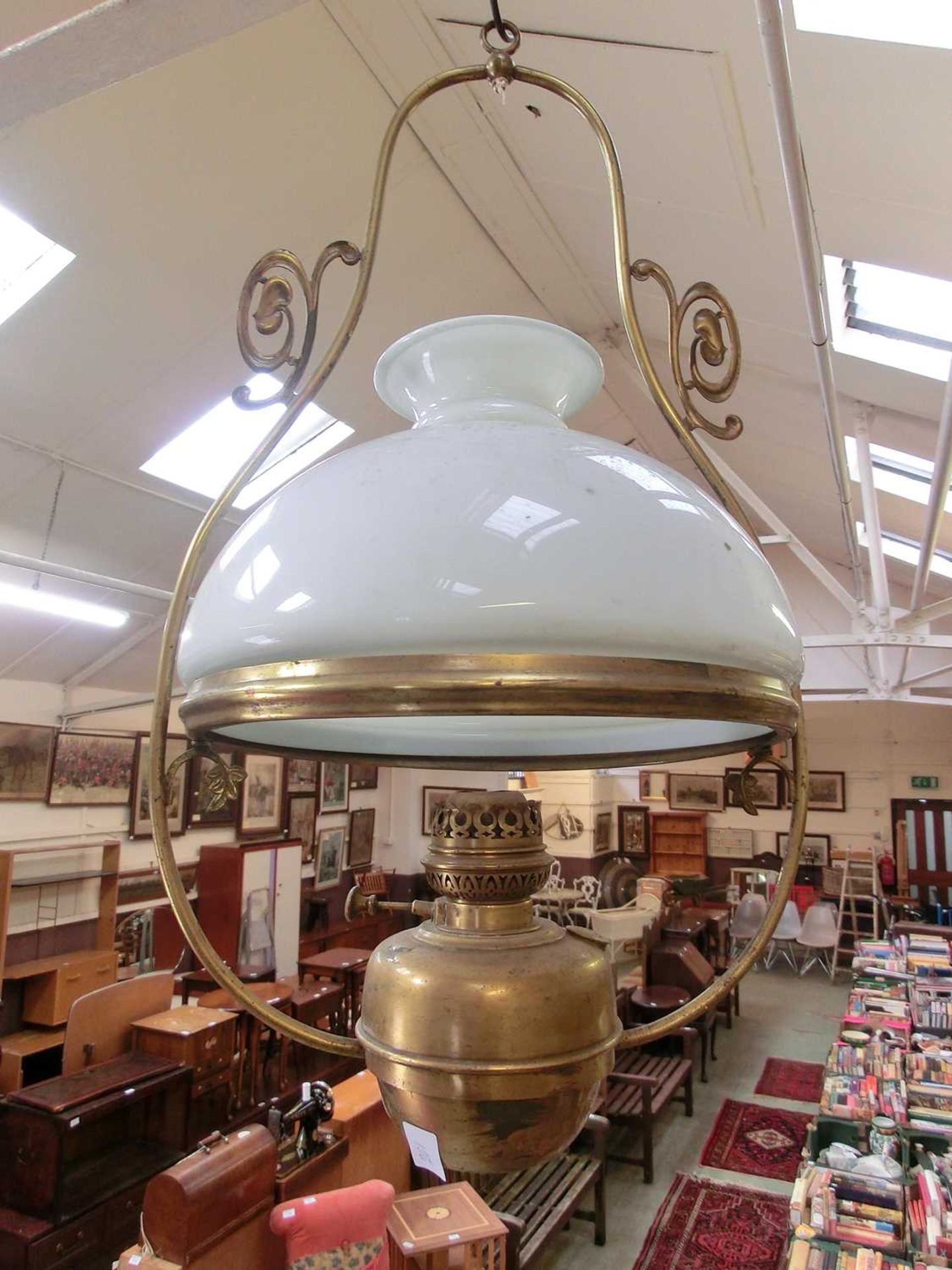 A brass and white glass ceiling hanging oil lamp