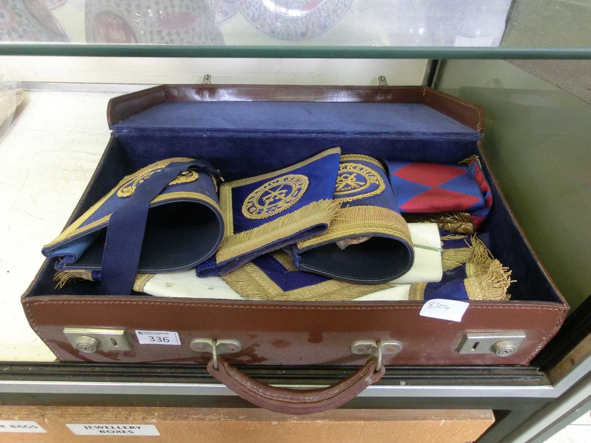 A brown fibre case containing a quantity of Masonic ephemera, armbands, etc