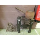 A cast iron fire grate along with a pot and two brackets