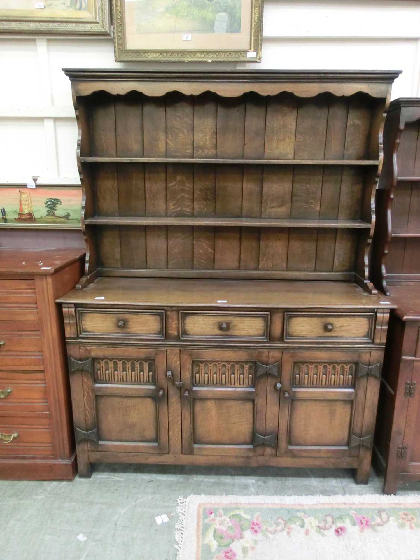 A reproduction dresser, the plate rack over three drawers and three carved panel doors