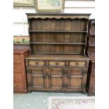 A reproduction dresser, the plate rack over three drawers and three carved panel doors