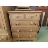 A modern pine chest of two short over three long drawers