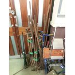A large selection of long handled garden tools