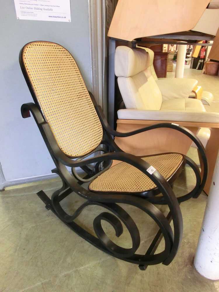An ebonised bent wood rocking chair with cane seat and back