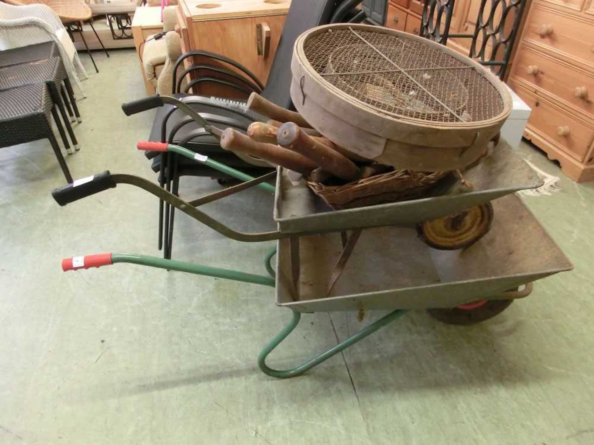 Two galvanised wheelbarrows together with a selection of hand tools and garden sieves