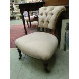 An Edwardian walnut framed nursing chair upholstered in a white gold button back fabric