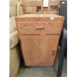 An artist's cabinet with a pair of lift up lids, a drawer, and a cupboard door