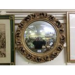 An ornate gilt framed convex mirror