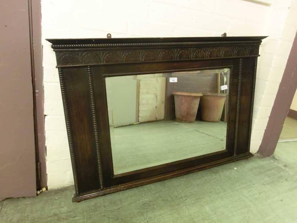 An early 20th century oak cased bevel glass over mantle mirror