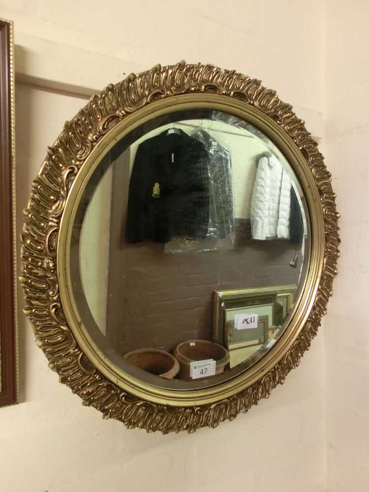 An ornate gilt framed circular bevel glass miror