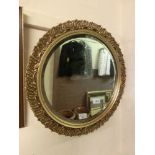 An ornate gilt framed circular bevel glass miror