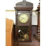 An early 20th century oak cased drop-dial wall clock