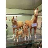 Two Beswick horses along with two Beswick foals