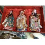 A cased set of ceramic oriental figures