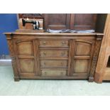 A high quality oak dresser base having four drawers flanked by cupboard doors