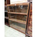 A mid-20th century three sectioned bookcase with glass sliding doors