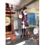 A moulded model of a well dressed horse-man hybrid holding a pocket watch