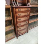 A reproduction flame mahogany serpentine fronted chest of six drawers